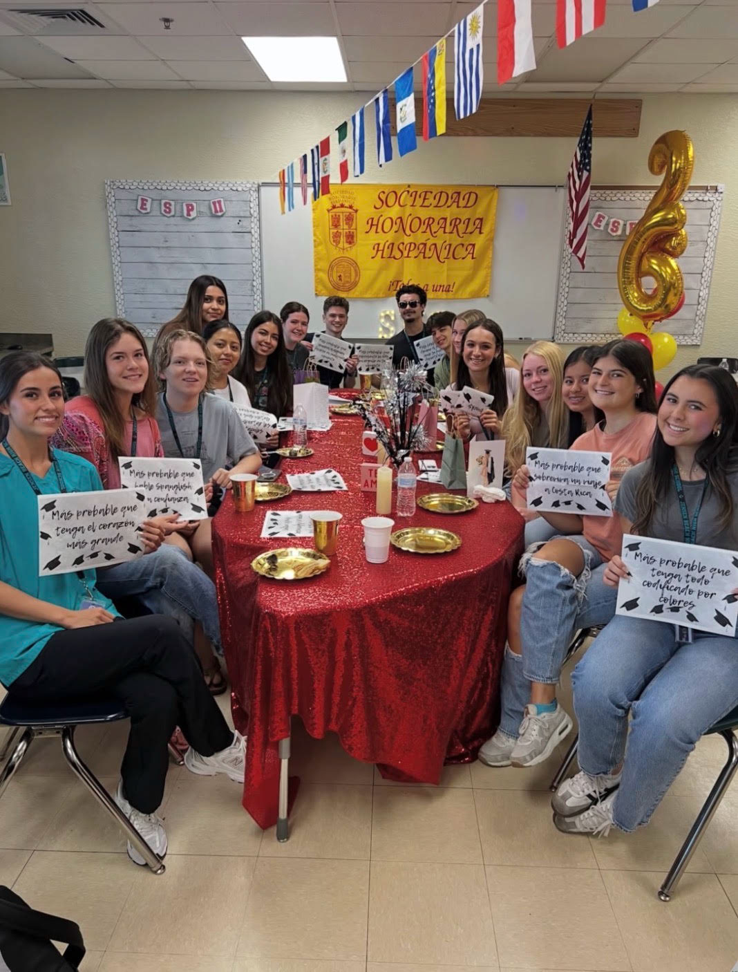 High school students celebrating at a Spanish cultural event, vibrant red and yellow decorations, joyful group photo